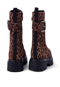 Stivaletti alla caviglia in stampa leopardata con finitura in suede, suola in gomma nera, dettaglio con fibbia laterale e testo in rilievo lungo la fascia posteriore.