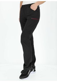 Black, lightweight outdoor pants with a fitted design, side zip pocket, and articulated knees for mobility, paired with black sneakers.