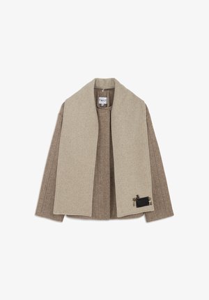 Cappotto in lana beige e marrone a spina di pesce con un ampio colletto beige, dotato di una tasca nera decorativa con dettagli sul lato sinistro.