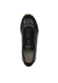 Zwarte sneaker met een gladde leren bovenkant, textuur suede accenten, vetersluiting en een rubberen zool met bruine tractiepatronen.