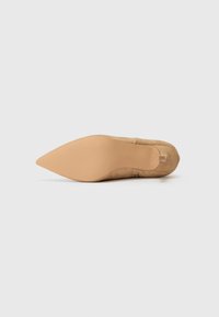 Beige kangashupud, millel on sile tekstuur ja õhuke kehatooniline tall. Omab minimalistlikku disaini ja peent libistamisstiili.