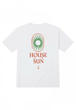 Camiseta de algodón blanca con un gráfico espiral verde en un óvalo y texto naranja que dice "CASA del SOL" en la parte posterior.