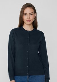 Cárdigan azul marino con cuello redondo, mangas largas y cierre de botones. Textura suave con puños y dobladillo acanalados.