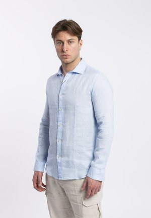 Camicia di lino azzurro chiaro con botonatura frontale, maniche lunghe e colletto. Presenta un tessuto texturizzato e bottoni visibili lungo la patta.