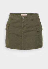 Oliivinvihreä mini-hame, jossa on edessä nappi, vyölenkit ja kaksi suurta sivutaskua tikkureunalla yksinkertaisella taustalla.