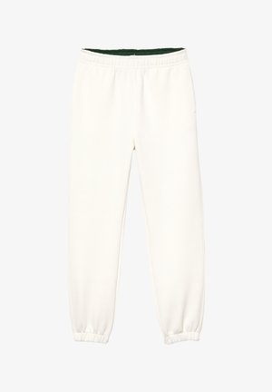 Pantalones deportivos blancos hechos de una tela suave, con cintura elástica y puños, y un forro interior verde en contraste. Diseño simple y recto.