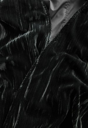 Black velvet fabric with wavy texture and subtle sheen. Edges are finished smoothly, featuring a rich pattern of light and dark stripes.