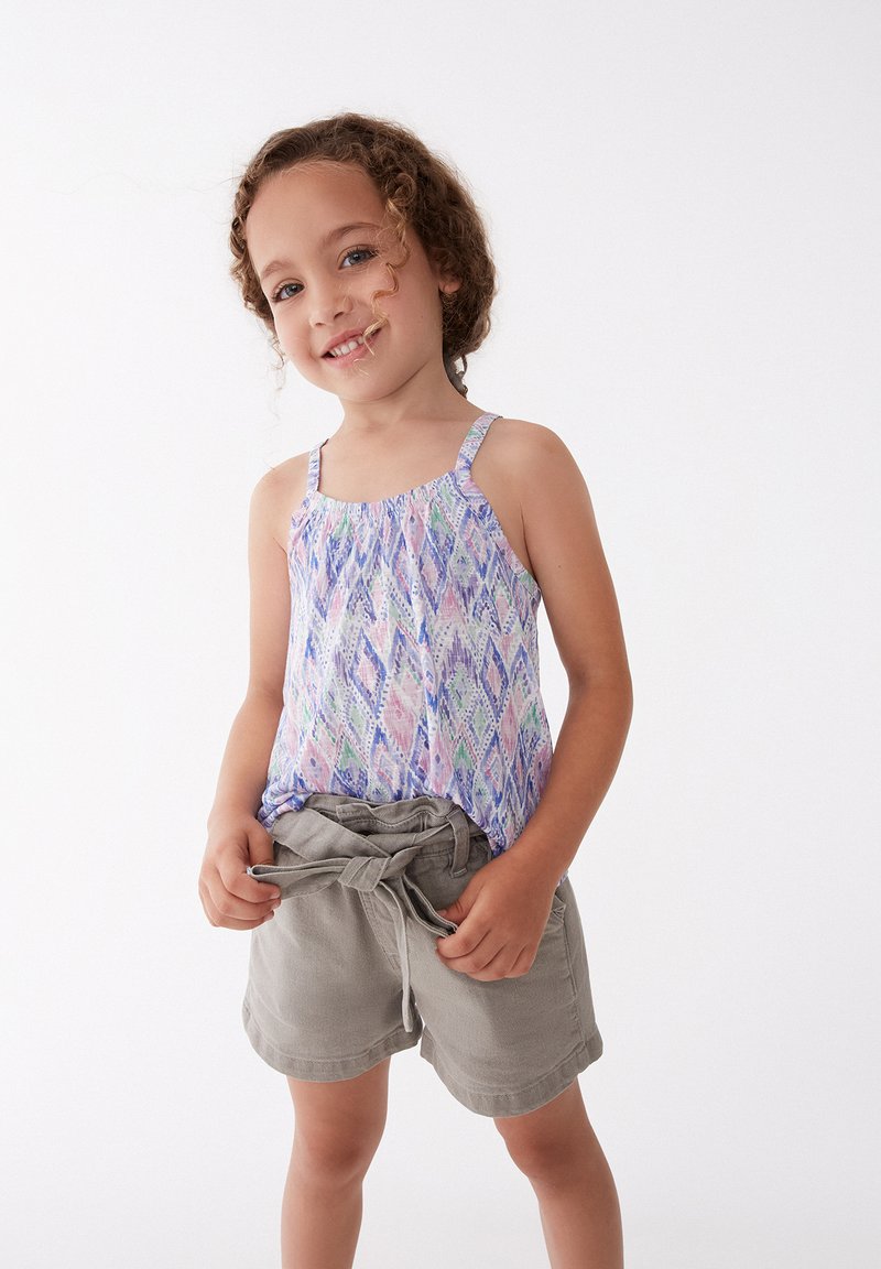 Top de tirantes multicolor con un patrón de diamantes, de tela ligera y con tirantes ajustables, combinado con unos pantalones cortos grises con cintura elástica.