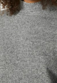 Maglione grigio a coste con colletto alto, caratterizzato da una texture morbida e leggere variazioni di tonalità sulla superficie del tessuto.
