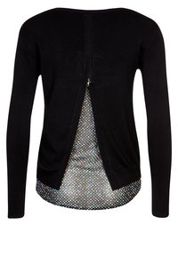 Černý top s dlouhým rukávem, zadním zipem a vnitřní vrstvou s puntíkovaným vzorem. Má kulatý výstřih a přiléhavé rukávy.