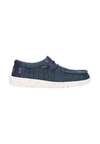 Chaussure décontractée bleu marine à enfiler avec dessus en tissu tricoté, détail de lacet et semelle épaisse blanche mouchetée.