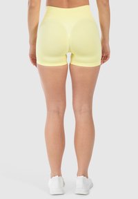 Hoge taille, nauwsluitende gele shorts van rekbaar stof, met een gladde textuur en een elastische tailleband.