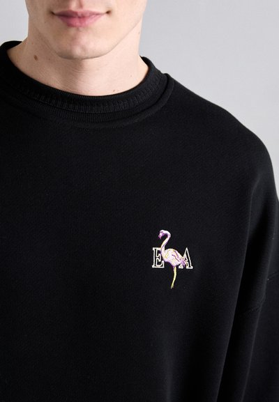 Sort sweatshirt med et broderet flamingo-design og teksten "E A" i farverige tråde, med rund hals og struktureret stof.