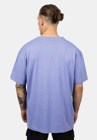 Purple cotton t-shirt with a relaxed fit, crew neck, and short sleeves. The fabric appears soft with a smooth texture.