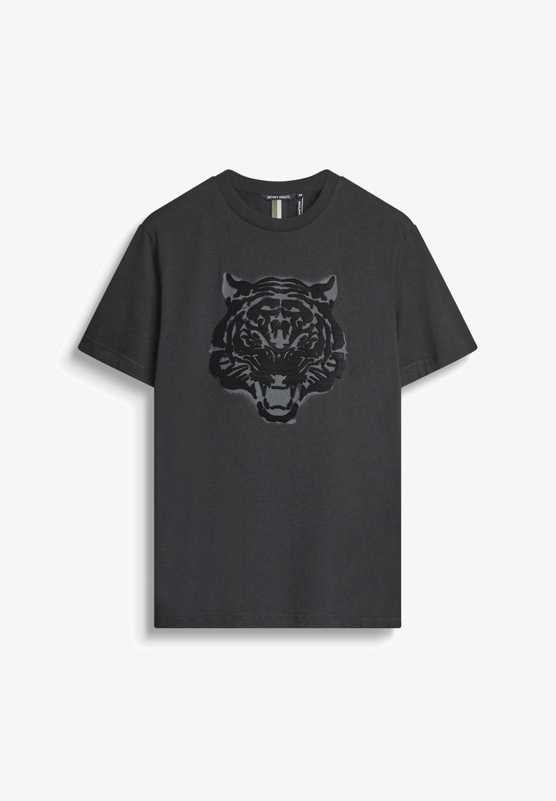 Camiseta de algodón negra con un gráfico de cabeza de tigre texturizado en un tono más oscuro. Cuello redondo clásico y mangas cortas.
