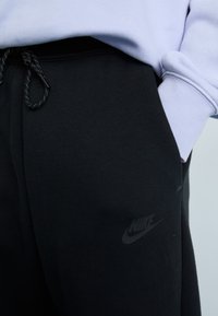 Melnas sporta bikses ar elastīgu jostasvietu, ar diskrētu Nike logotipu. Izgatavotas no mīksta auduma ar gludu tekstūru.