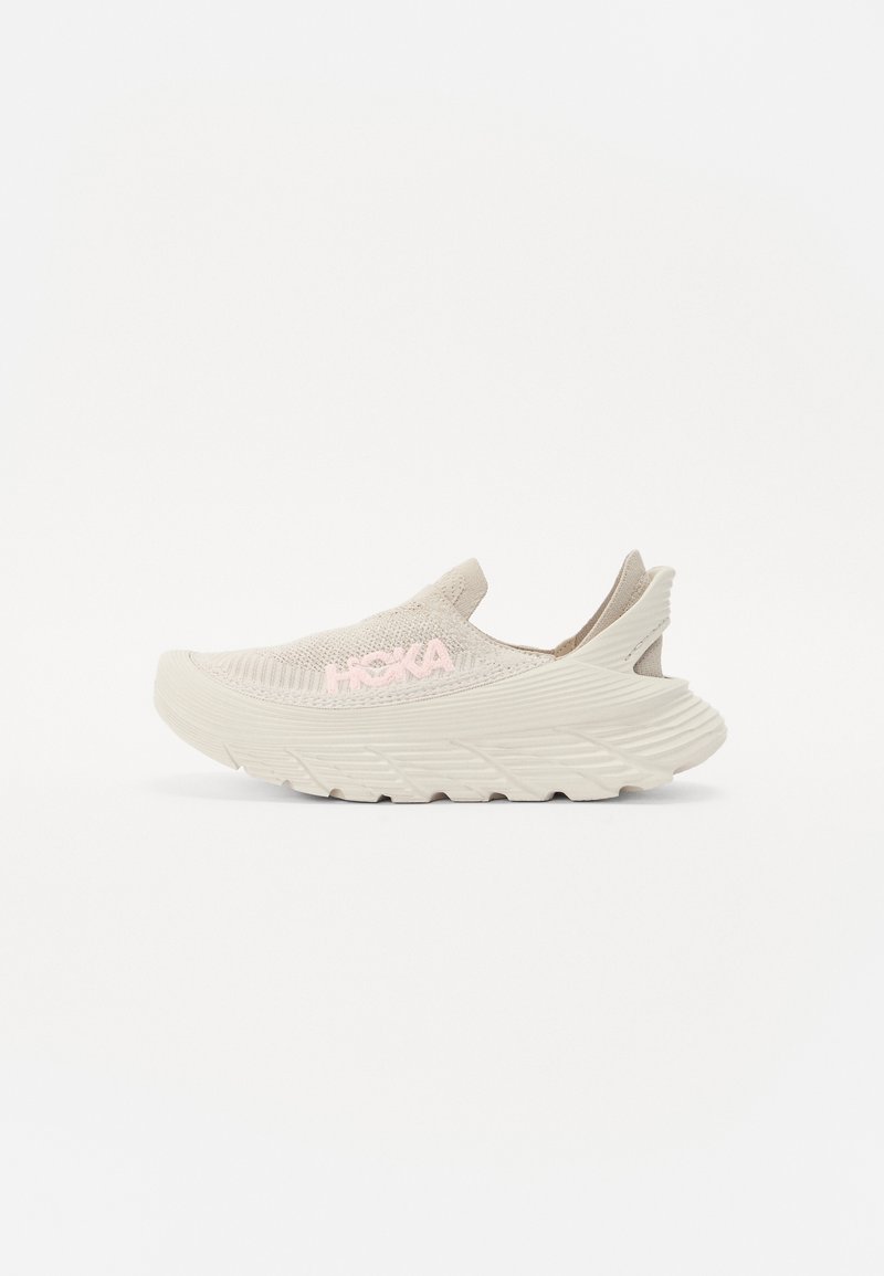 Beige slip-on sneaker texturált kötött felsőrésszel és világos rózsaszín logóval. Jellemzője egy vastag talp, amely markáns mintázatú, és támogató kialakítással rendelkezik.