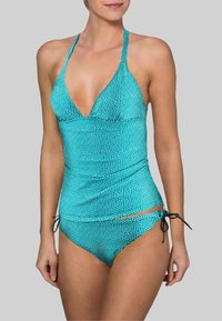 Bikini turquoise à pois avec un décolleté en V profond, des bretelles halter ajustables et des liens sur le bas. Tissu lisse et extensible.