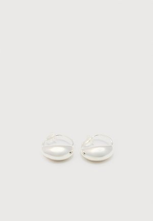 Small silver hoop earrings with a smooth, rounded design and clear plastic backings on a plain white background.
