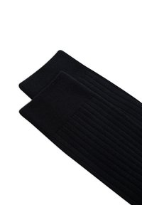 Calze a coste nere fino al ginocchio con una texture morbida e un bordo superiore rinforzato, che mostrano un motivo a maglia liscio e uniforme in tutto.