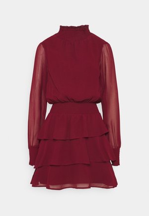Robe bordeaux à col montant avec manches longues transparentes, taille et col froncés, et jupe à volants superposés.