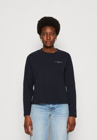 T-shirt a manica lunga blu navy in cotone con collo a giro. Presenta un piccolo logo stampato sul petto e maniche a vestibilità comoda.