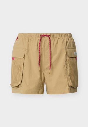 Μπεζ cargo σορτς με ελαστική μέση, κόκκινο κορδόνι και μεγάλες τσέπες με καπάκια και διχτυωτές επιφάνειες και στις δύο πλευρές.