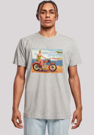 Gray cotton t-shirt featuring a vintage print of a woman on a motorcycle, with green accents and colorful background details.