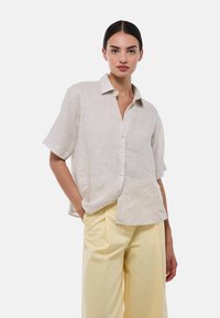 Chemise boutonnée courte à manches courtes rayée beige clair avec une coupe décontractée, dotée d'un col et d'un ourlet droit, associée à un pantalon jaune clair.