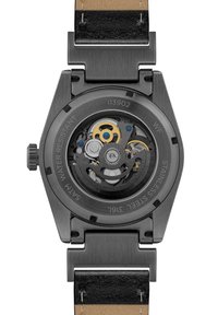 Schwarzes Edelstahlgehäuse mit transparentem Rücken, der komplizierte Zahnräder zeigt. Ausgestattet mit einem schwarzen Lederarmband und geprägten Details.