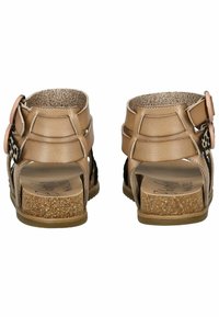 Hnědé sandály s otevřenou patou a strappy designem, s korkovou podrážkou a vrstvenými akcenty. Texturovaný látkový interiér a nastavitelné kovové prvky.