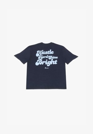 Donkerblauwe katoenen T-shirt met opvallende, witte tekst: "Hustle Hard Shine Bright." Relaxte pasvorm, korte mouwen en ronde hals.