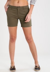 Pantaloni corti verde oliva realizzati in tessuto misto cotone, con zip frontale e tasche. Orlo con leggero risvolto, che si abbina con scarpe con stampa leopardata.