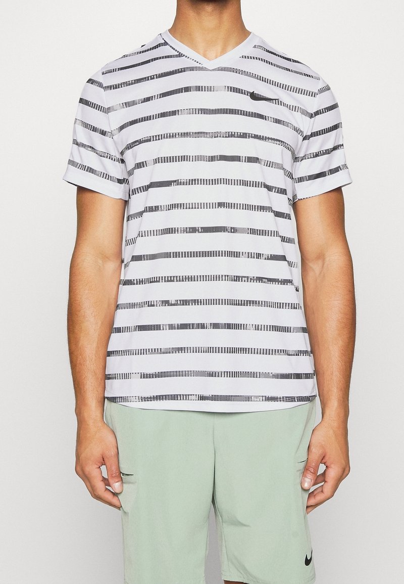 Randig kortärmad T-shirt med V-ringning i vitt med svarta horisontella linjer och texturerade detaljer. Tillverkad av lätt tyg, erbjuder den en avslappnad passform.