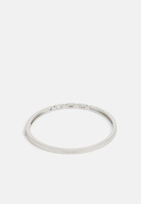 Silvrigt metallarmband med en slät, polerad yta. Har en subtil märkning och en minimalistisk design. Tunn och rund form.