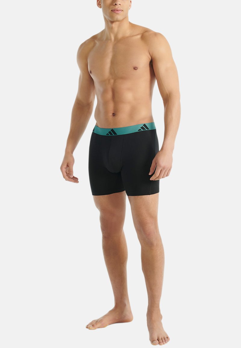 Zwarte boxershorts met een turquoise band, gemaakt van een zachte stof, tot halverwege de dij lengte, en subtiele branding op de tailleband.