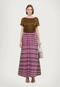 Top in satin marrone con scollatura ampia abbinato a una lunga gonna a quadri con tonalità di rosa, viola e marrone. Tessuto liscio, vita elastica.