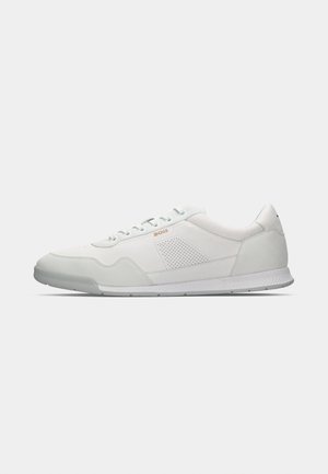 Weiße Sportschuhe mit einem glatten Lederobermaterial, hellgrauen Akzenten, perforierten Seitenpaneelen und einer strukturierten Gummisohle.