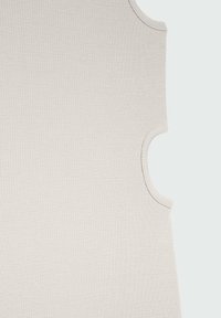 Gros plan d'un haut sans manches en maille côtelée beige montrant l'encolure ronde et le tissu texturé.