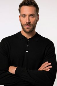 Schwarzes gestricktes Poloshirt mit einer Knopfleiste mit drei Knöpfen, langen Ärmeln und gerippten Bündchen. Glatte Textur und taillierte Passform.