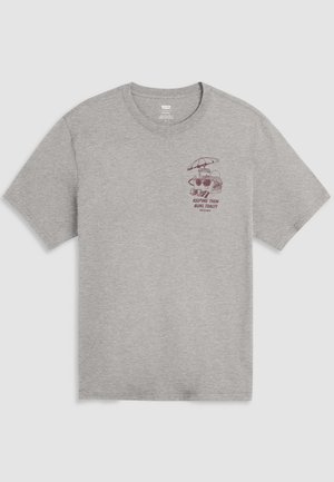 Siva majica s okruglim izrezom i malim tamnocrvenim grafičkim prikazom toster ispod kišobrana te tekstom "Keeping them buns toasty since 1873" na lijevoj strani prsa.