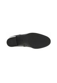 Suela de zapato de cuero negro con textura decorada y bordes suaves. Presenta un logotipo grabado en la zona del talón y un fondo de goma plana.
