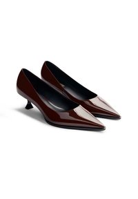 Zapatos de tacón de charol marrón con punta afilada y un pequeño y único tacón de gatito. Plantillas negras y un acabado suave y brillante.