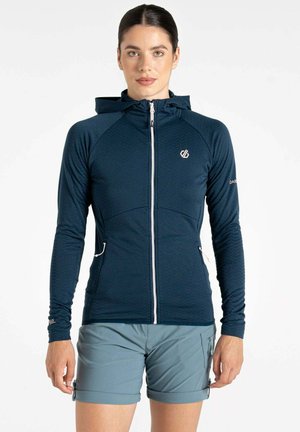 Marineblaues Kapuzensweatshirt mit Reißverschluss vorne, strukturierten Einsätzen und Seitentaschen. Begleitet von hellgrauen Shorts mit Reißverschlussdetails.