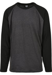 Långärmad T-shirt med en mörkgrå kropp och svarta raglanärmar, tillverkad av mjukt material med rund hals och avslappnad passform.