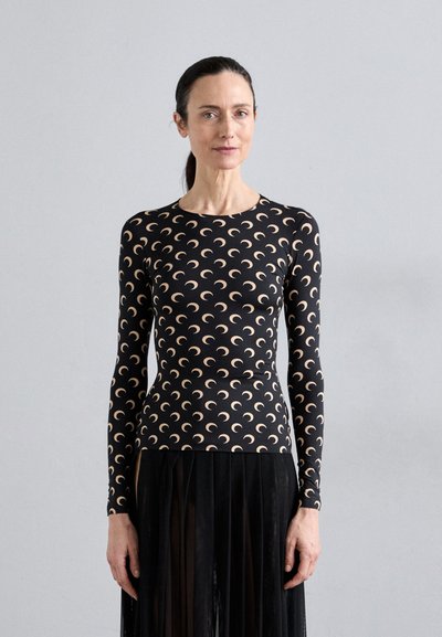 Long-sleeve black top with a beige crescent moon pattern, featuring a round neckline and a fitted design, made from stretchable material.