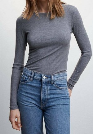 Graues langärmliges geripptes Oberteil kombiniert mit hoch taillierten hellblauen Jeans. Der Stoff wirkt weich, hat eine figurbetonte Passform und einen klassischen Ausschnitt.