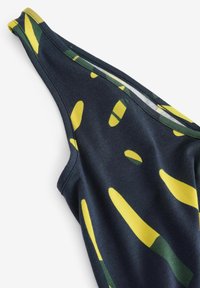 Svart linne med ett livligt gult och grönt abstrakt mönster. Slätt tyg med en figurnära design och breda axelband.
