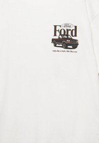Logo Ford au-dessus d'une illustration classique d'un camion noir avec le texte « fonctionne comme un camion, roule comme une voiture » sur fond blanc.