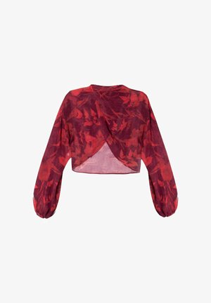 Blouse rouge courte avec de longues manches bouffantes et un design croisé. Elle présente un motif floral et une texture translucide.
